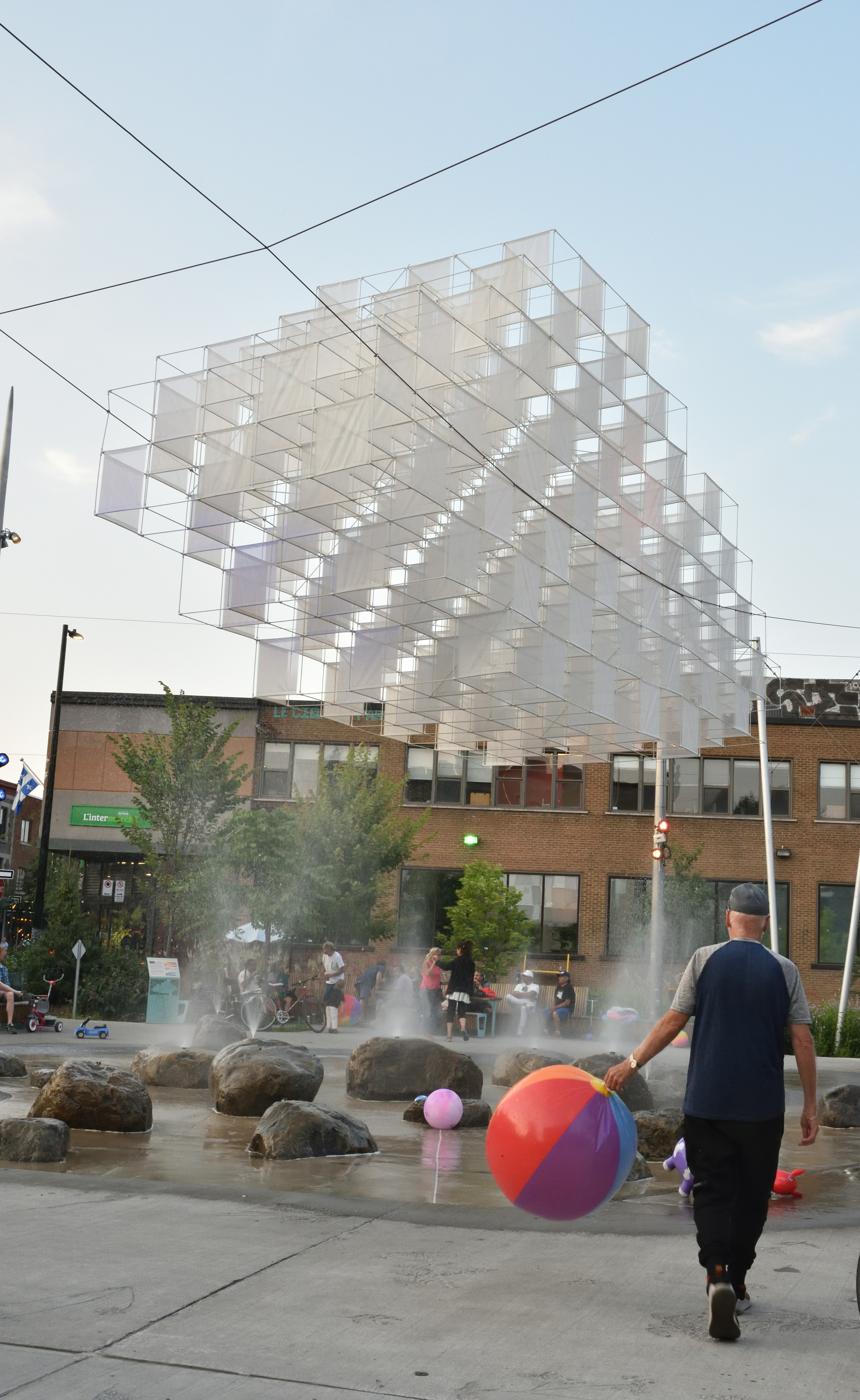 ein Mann, der eine Straße entlanggeht und einen großen Ball trägt