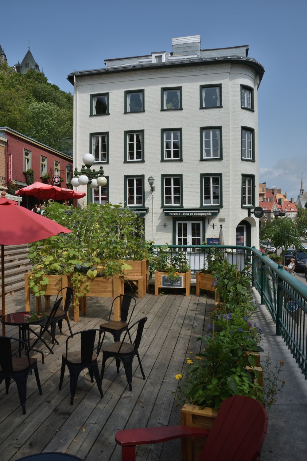 a wooden deck with tables and chairs next to a building