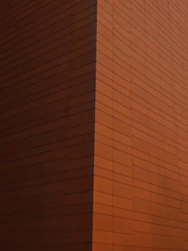 Modern residential building with minimalist architecture in Asturias, showcasing clean lines and warm rust tones.