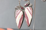 A striking pair of earrings featuring rich reds and blues with artistic flair.