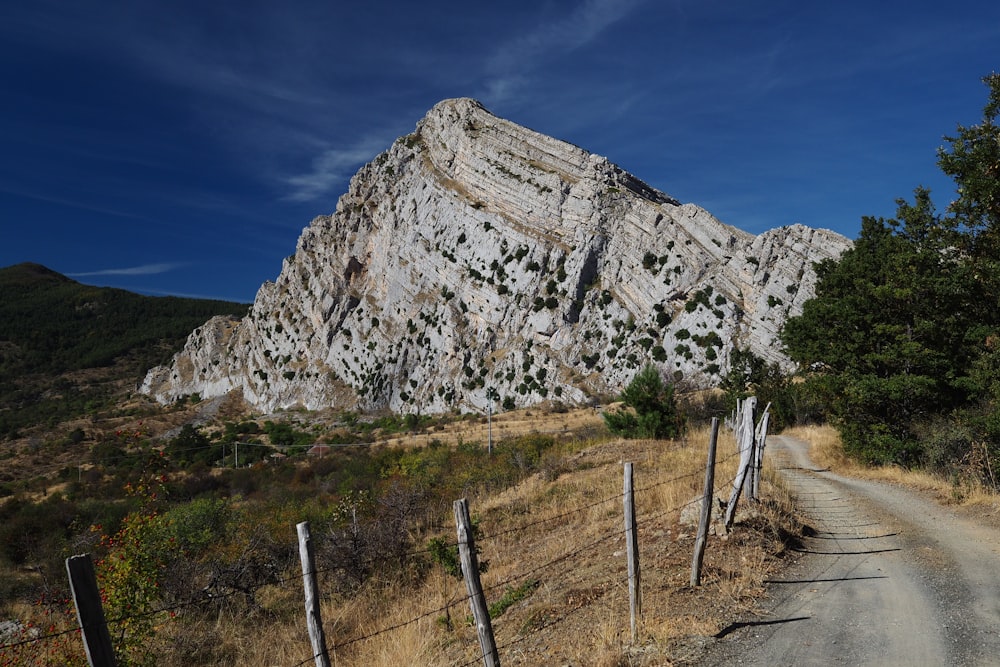 a dirt road in front of a large mountain