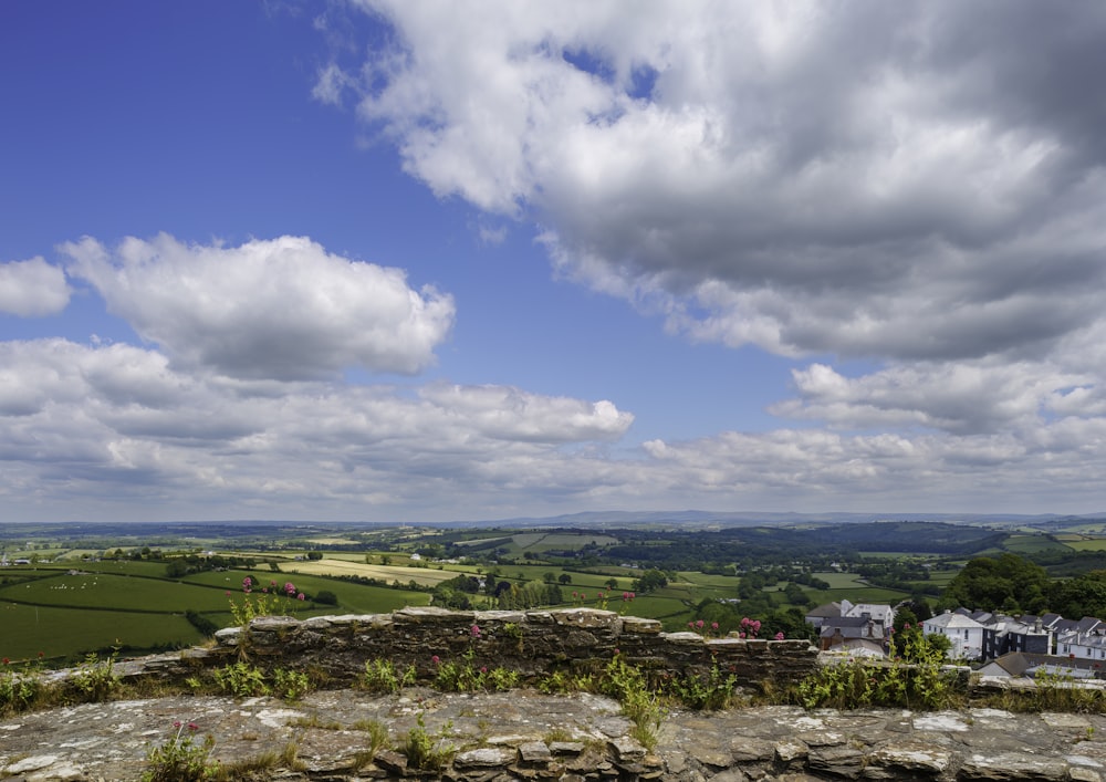 a stone wall with a view of the countryside