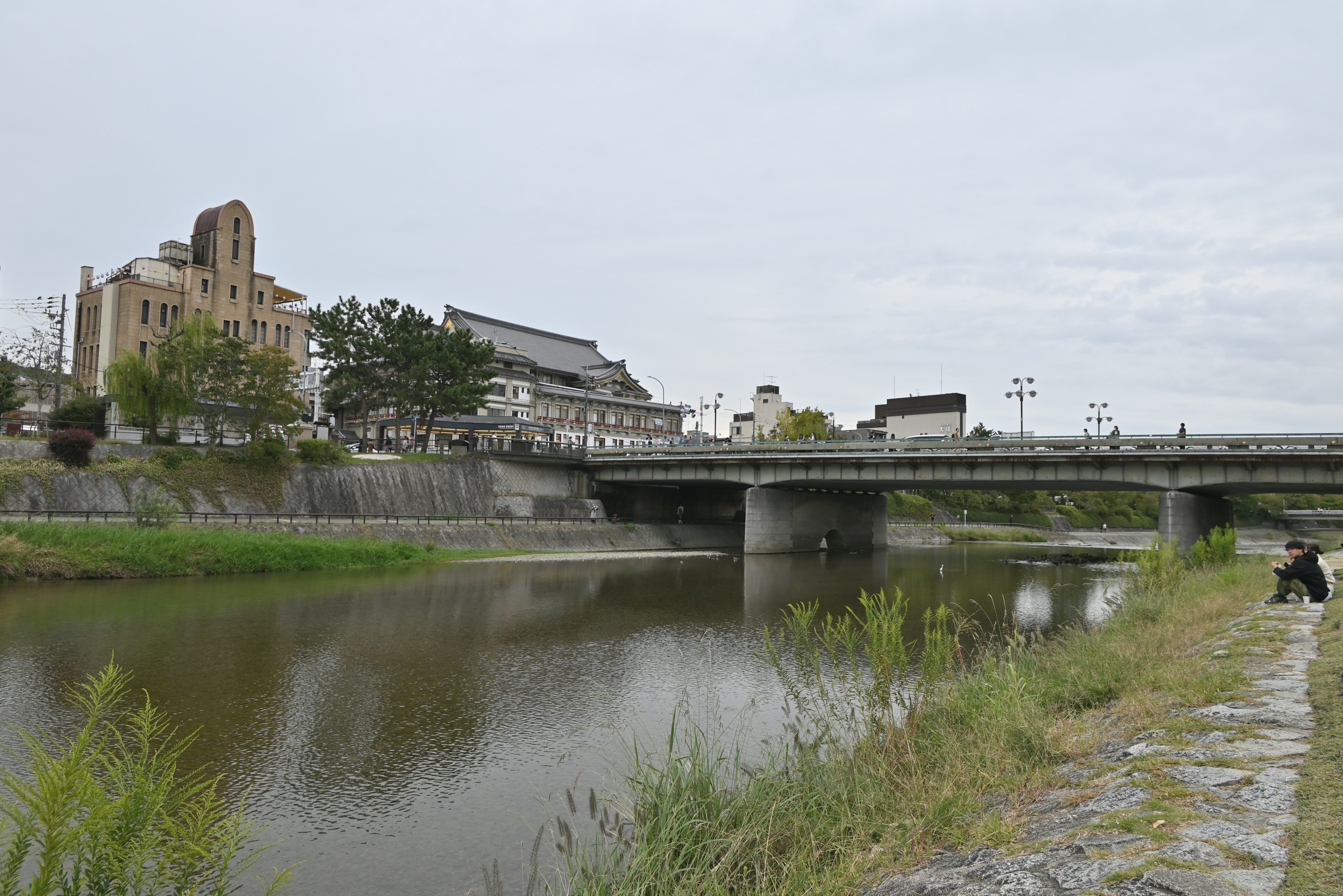 a man walking across a bridge over a river