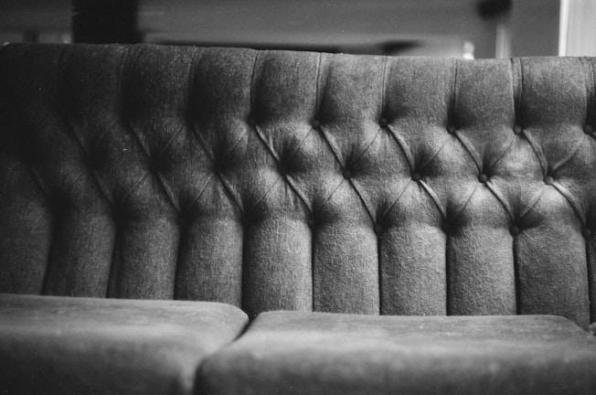 Before and after photo of a deeply cleaned upholstered sofa in a Parisian apartment.
