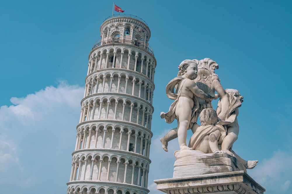 a tall tower with a statue next to it