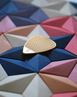 Close-up of a colorful custom guitar pick with intricate band logo design.