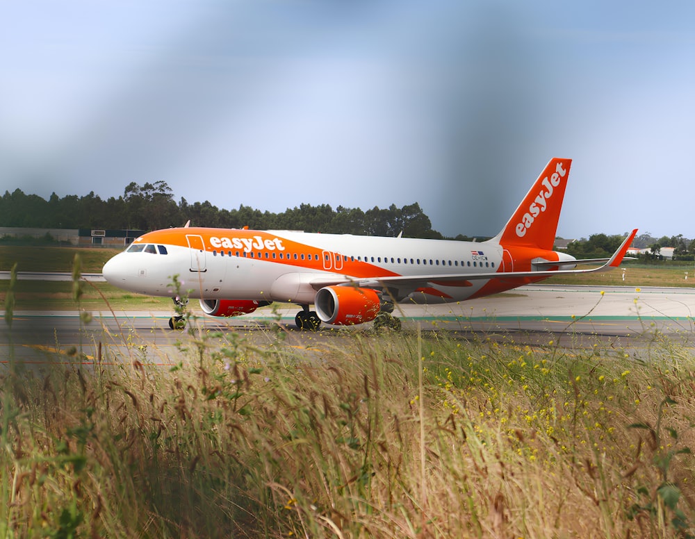 an orange and white airplane is on the runway