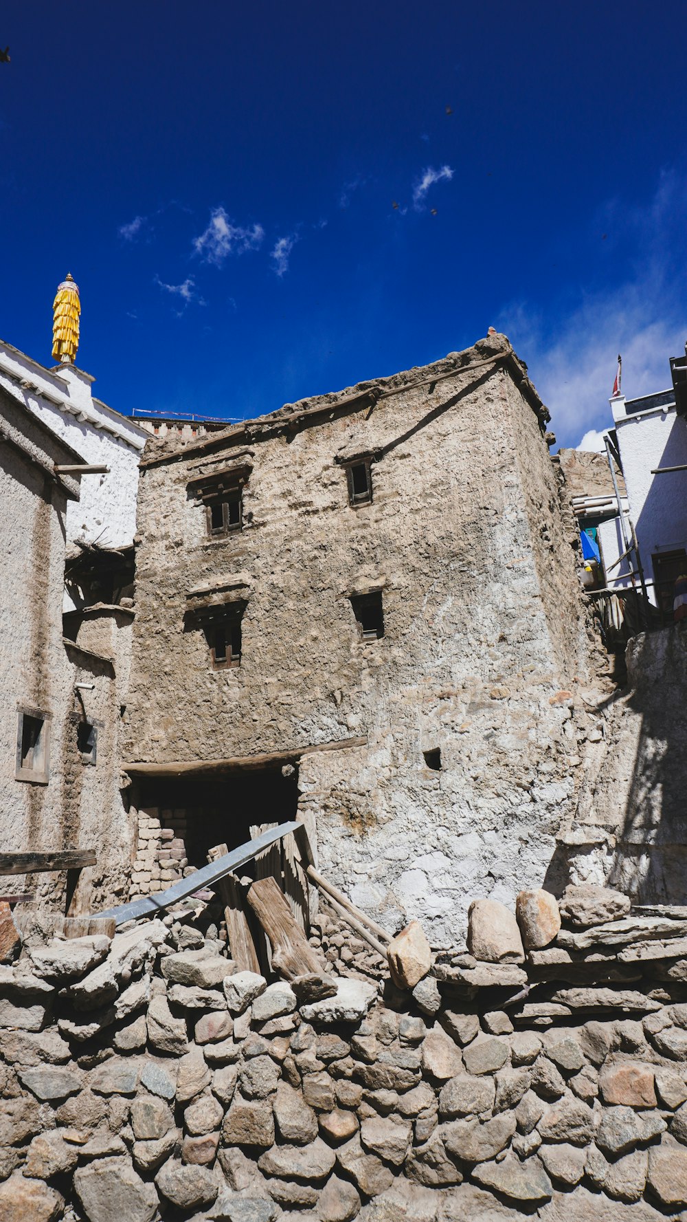 a stone building with a yellow statue on top of it