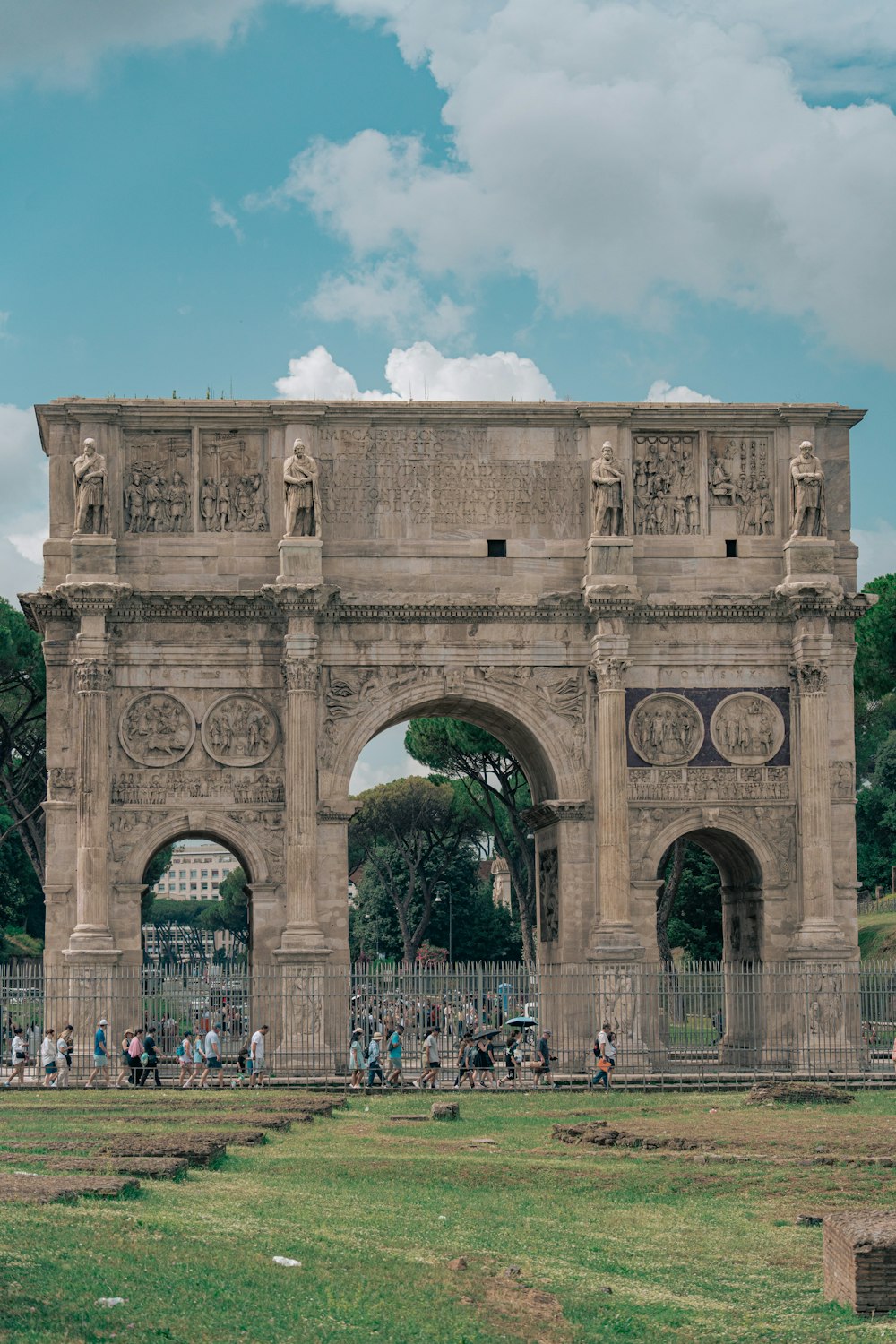 a group of people standing in front of a stone arch