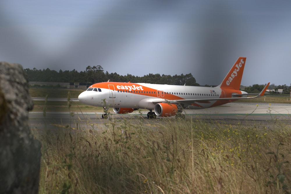 an orange and white airplane is on the runway