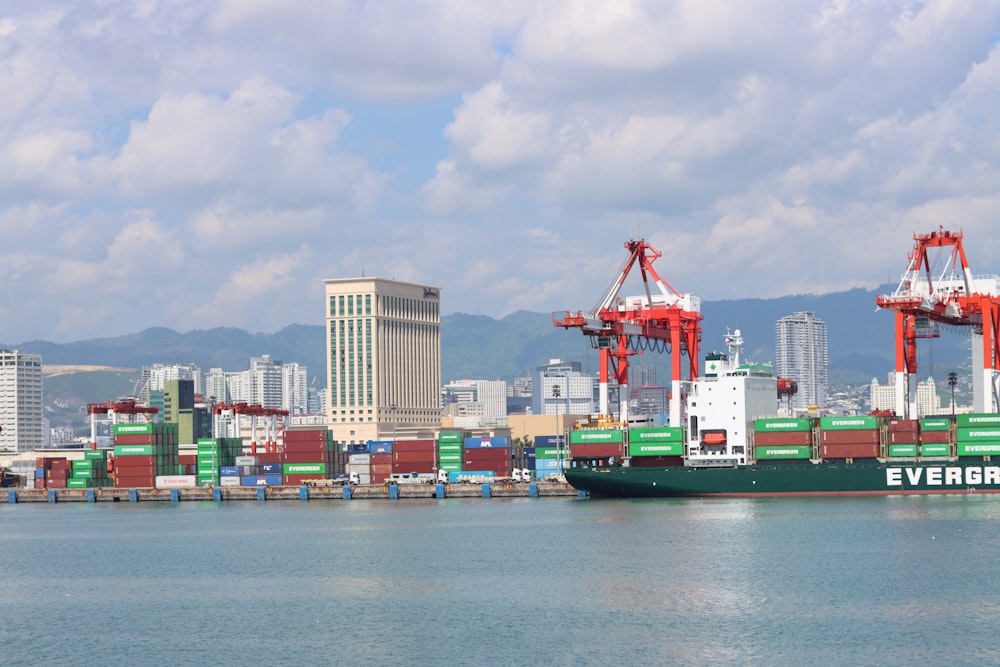 a large cargo ship in a harbor with a city in the background