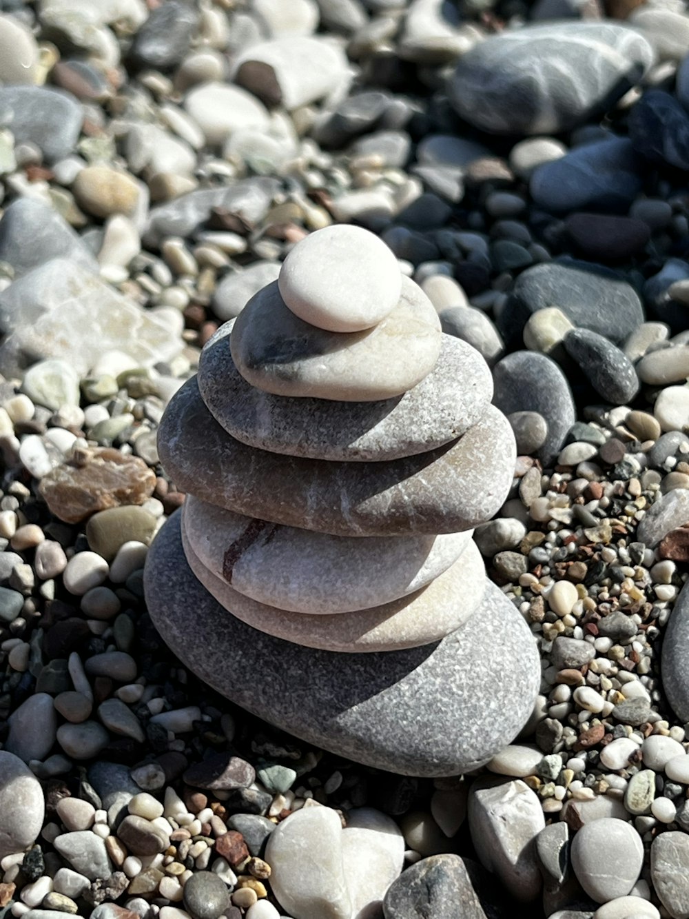 uma pilha de rochas sentada no topo de uma praia rochosa