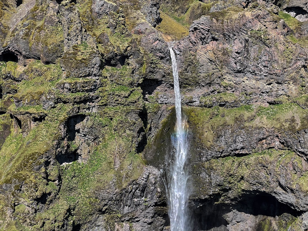 uma cachoeira com um arco-íris no meio dela