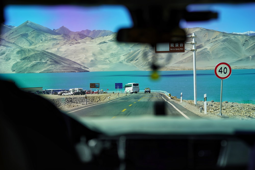 a view from inside a vehicle of a lake and mountains