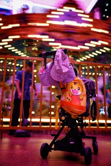 a child's stroller in front of a carousel