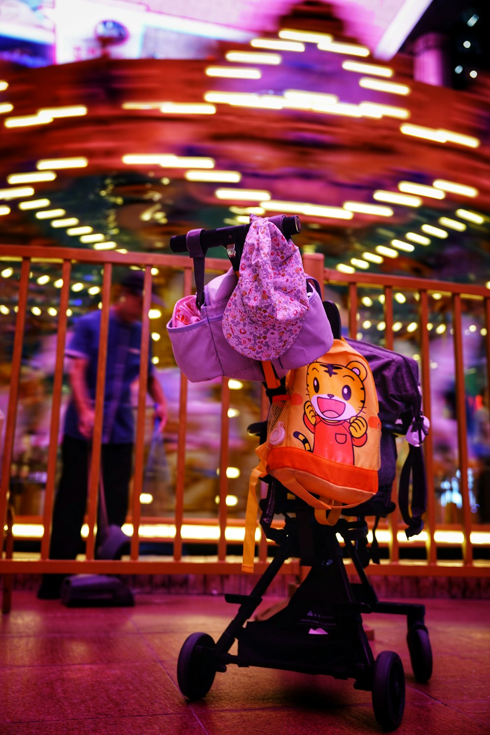a child's stroller in front of a carousel