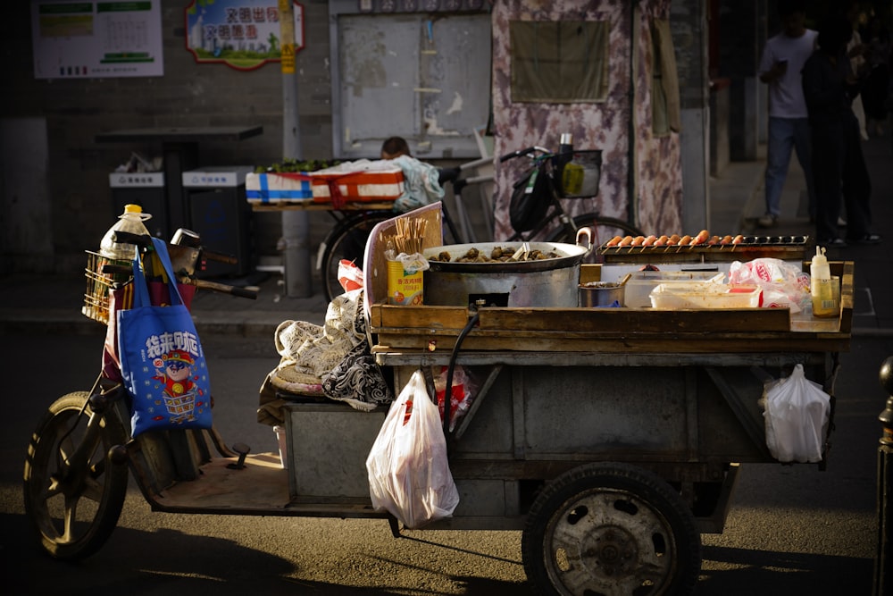 a cart full of food sitting on the side of a road