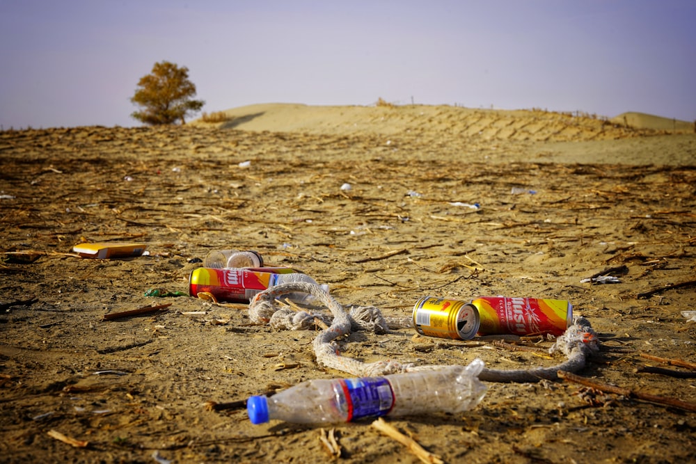a group of empty cans sitting on top of a dirt field