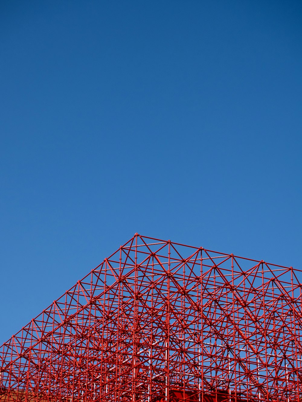 Ein Flugzeug, das unter blauem Himmel über ein rotes Gebäude fliegt