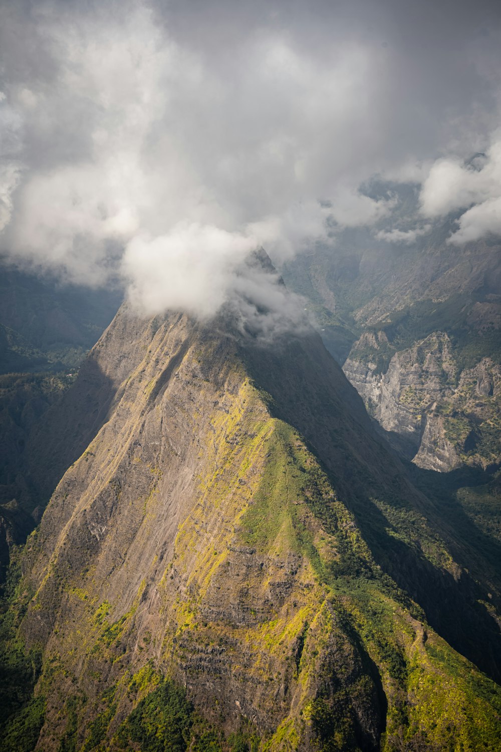 a very tall mountain with some clouds in the sky