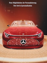 A sleek, futuristic red car is prominently displayed with a shiny and modern design. The car features a distinctive logo on the front grille and is set against a stylish background with warm, orange lighting. The words 'Neue Möglichkeiten der Personalisierung' and 'New level of personalization' are visible above the car, emphasizing a theme of innovation and customization.