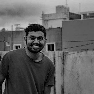 A happy customer wearing a personalized t-shirt, smiling outdoors with a city background.