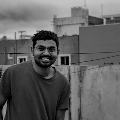 A happy customer wearing a personalized t-shirt, smiling outdoors with a city background.