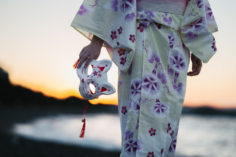 a person in a kimono walking by the water