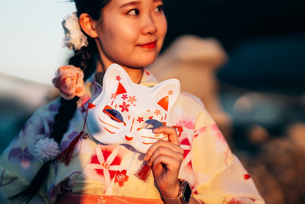 eine Frau im Kimono mit einer Katzenmaske