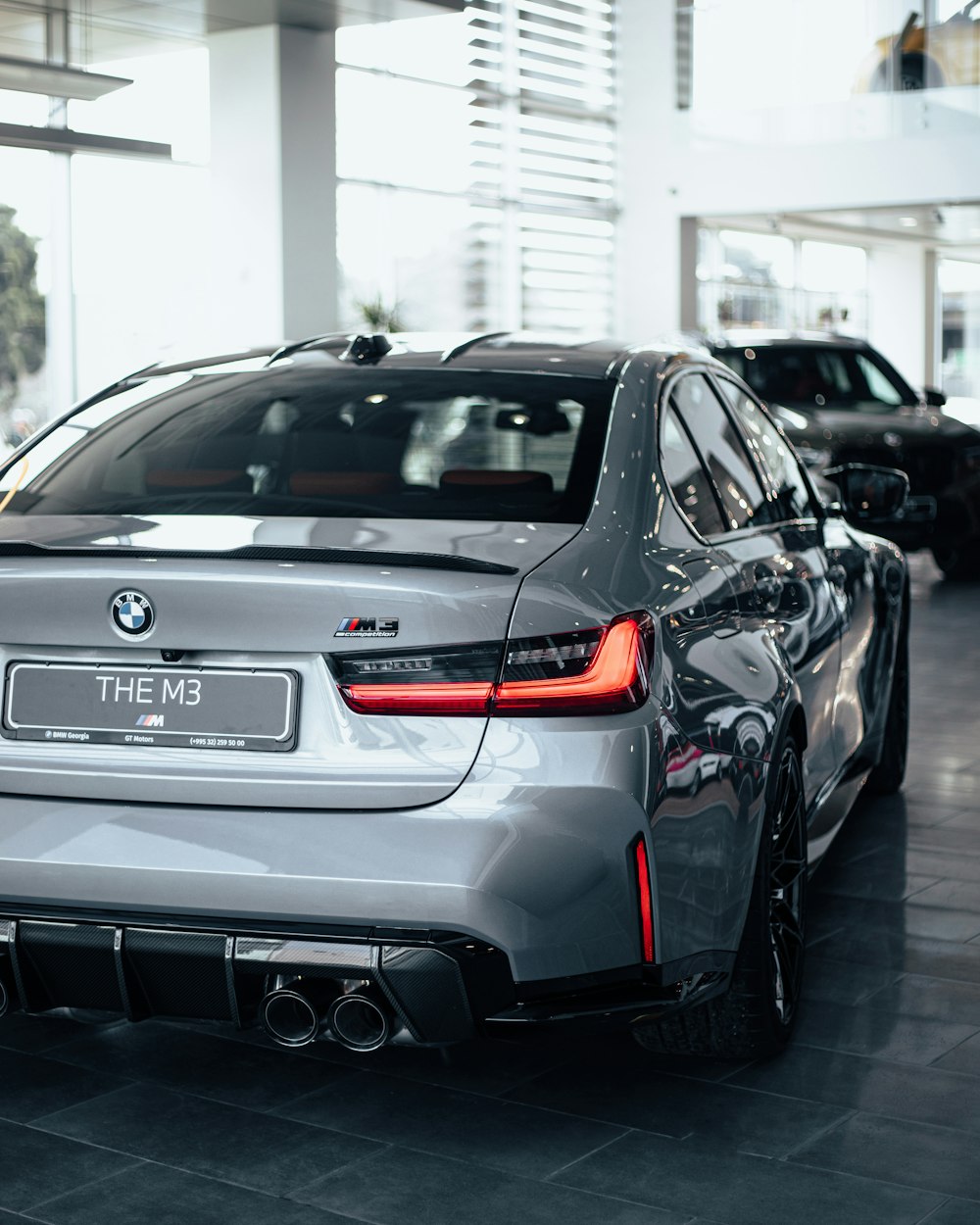 a silver car is parked in a showroom