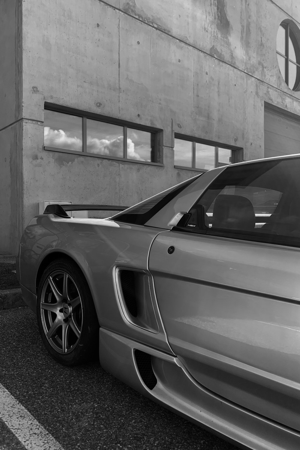 a silver sports car parked in front of a building