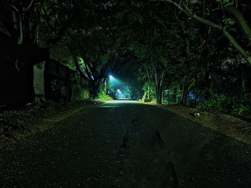 a dark street with a light at the end of it