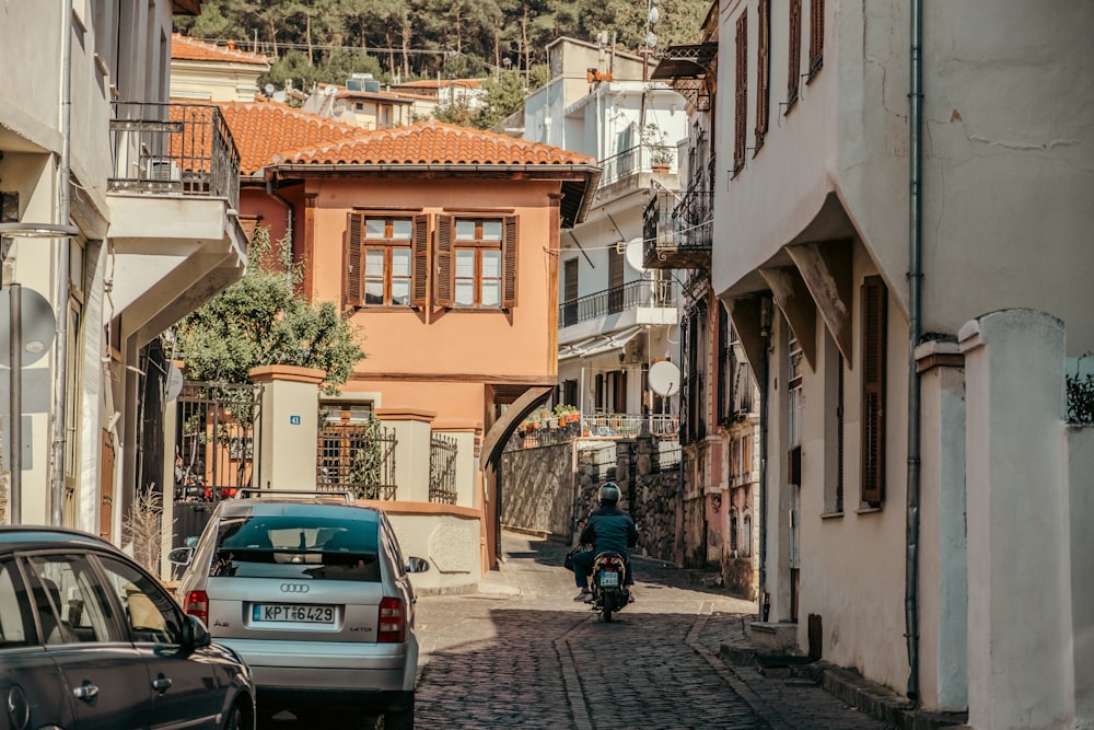 a man riding a motorcycle down a cobblestone street