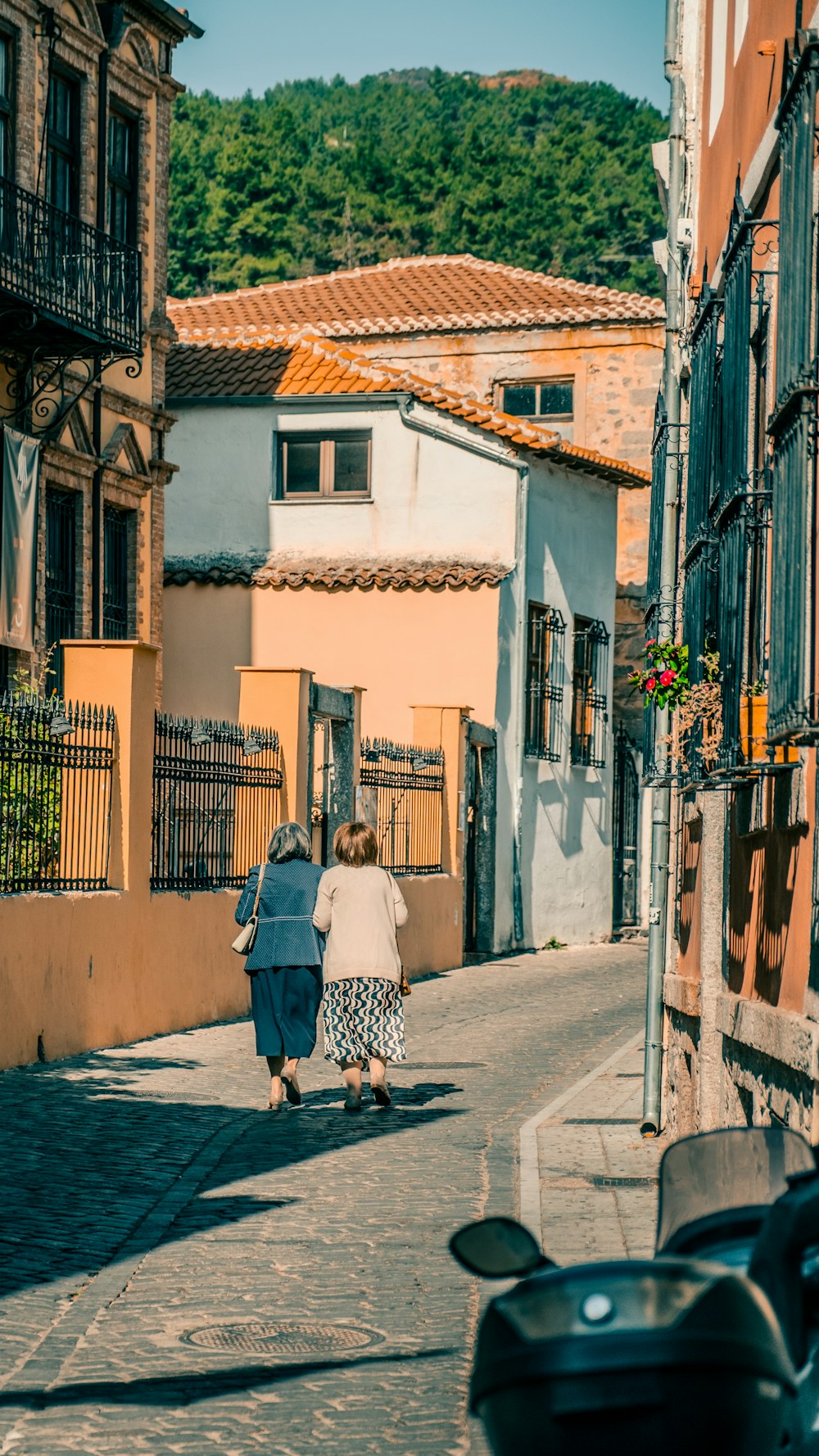 a couple of people walking down a street