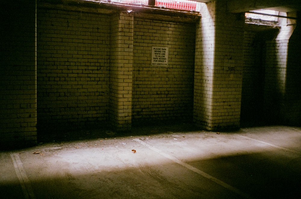 a dark room with a brick wall and a sign on the wall