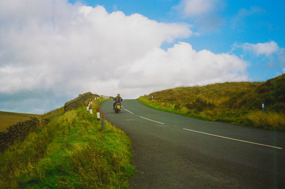 a group of people riding motorcycles down a curvy road