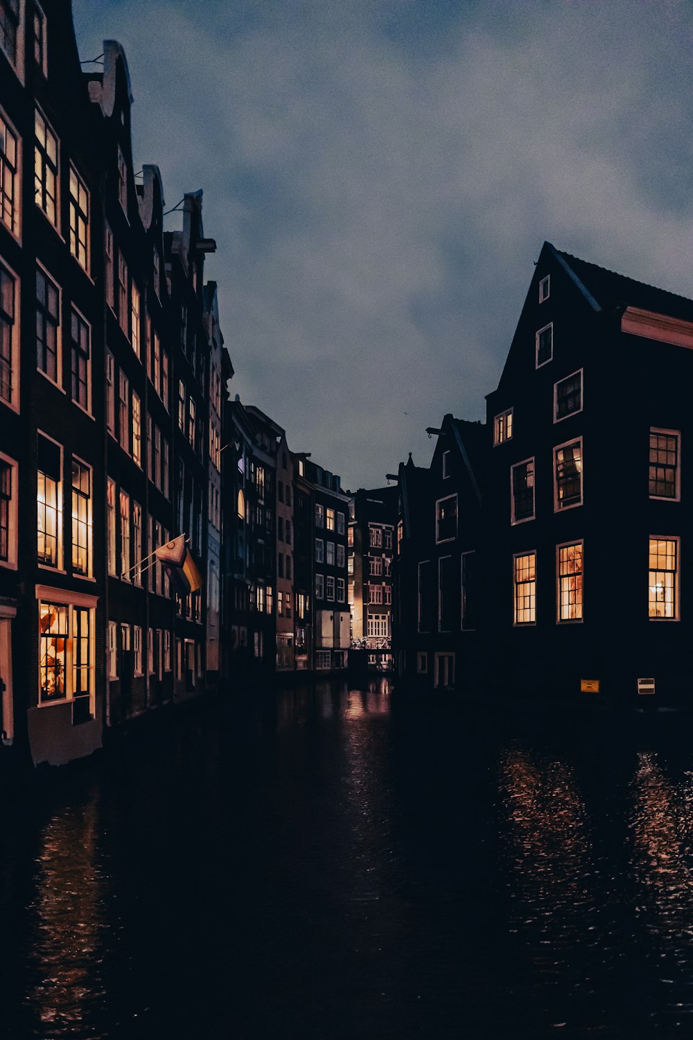 a dark street with some buildings and lights on