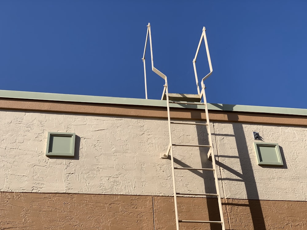 a ladder leaning against a building with two windows