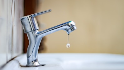 a faucet with a drop of water coming out of it