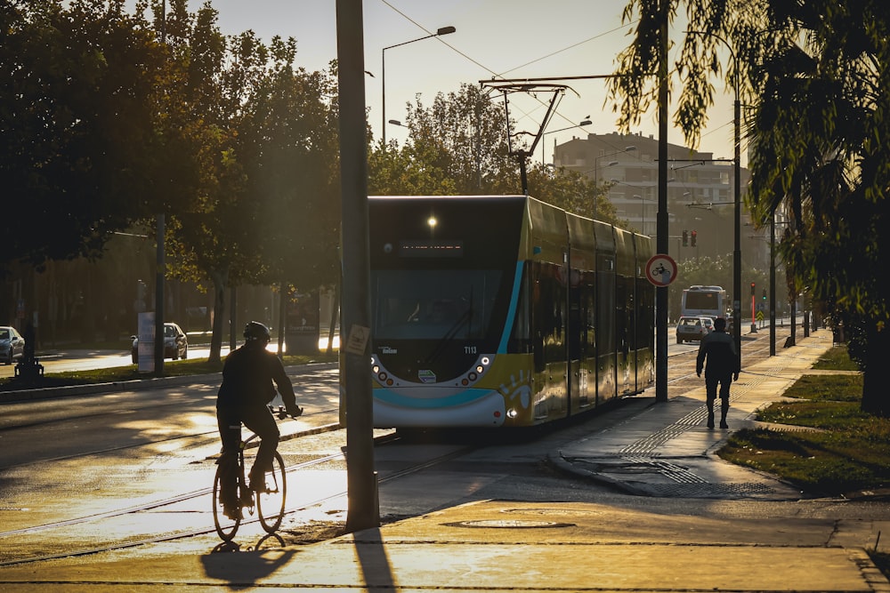 a man riding a bike down a street next to a bus