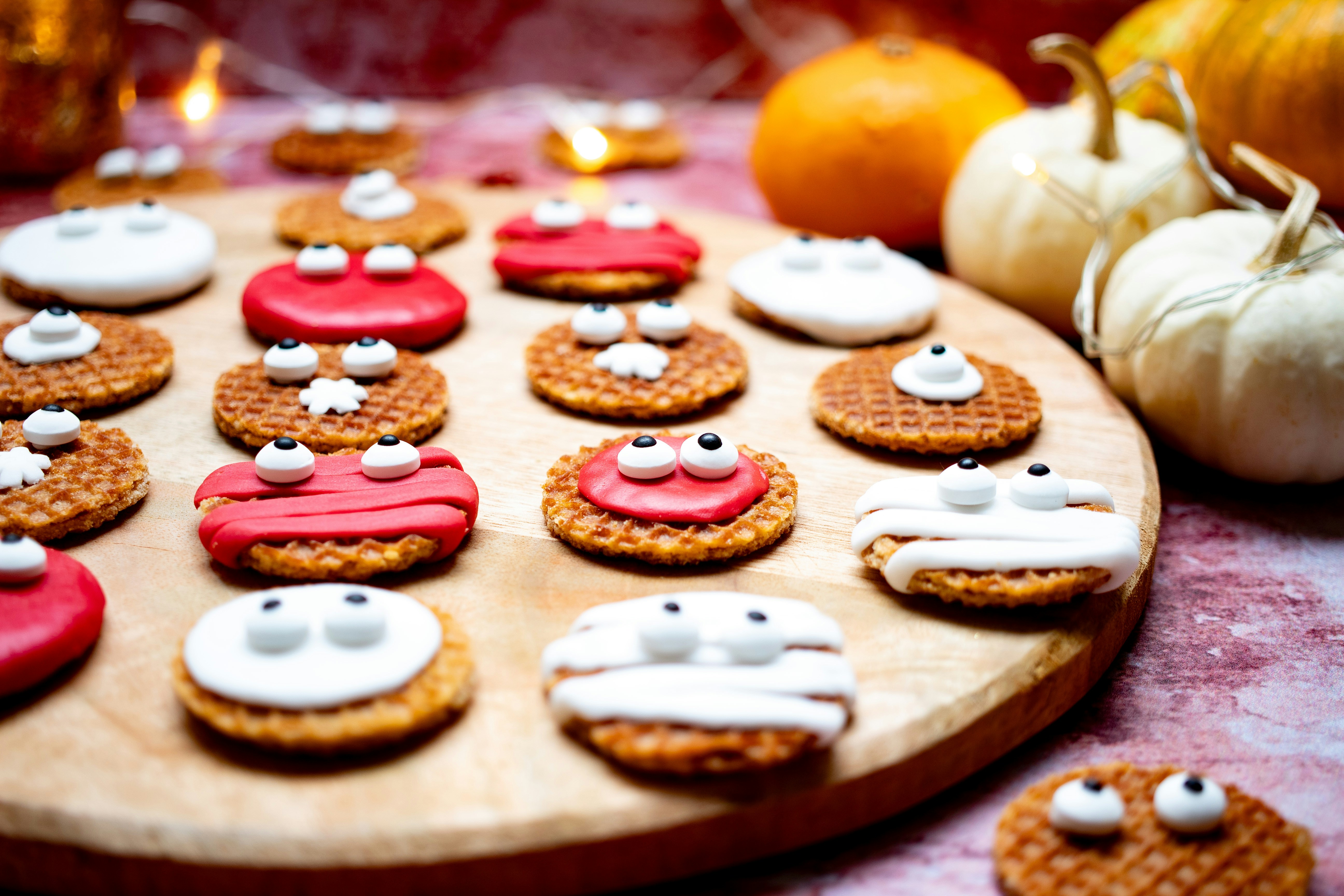 a wooden board topped with cookies covered in frosting