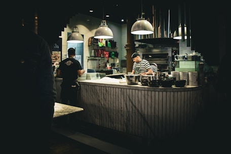 a couple of people that are standing in a kitchen