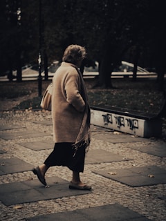 An elderly individual confidently living independently outdoors, wearing the discreet vytrex device