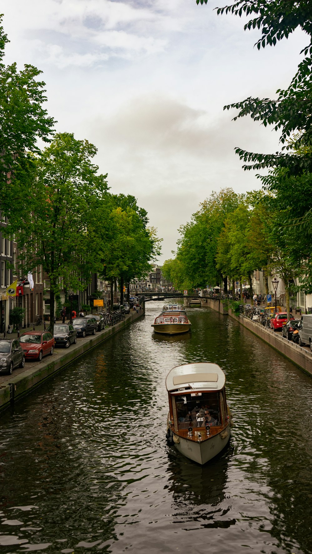 two boats are traveling down a narrow canal