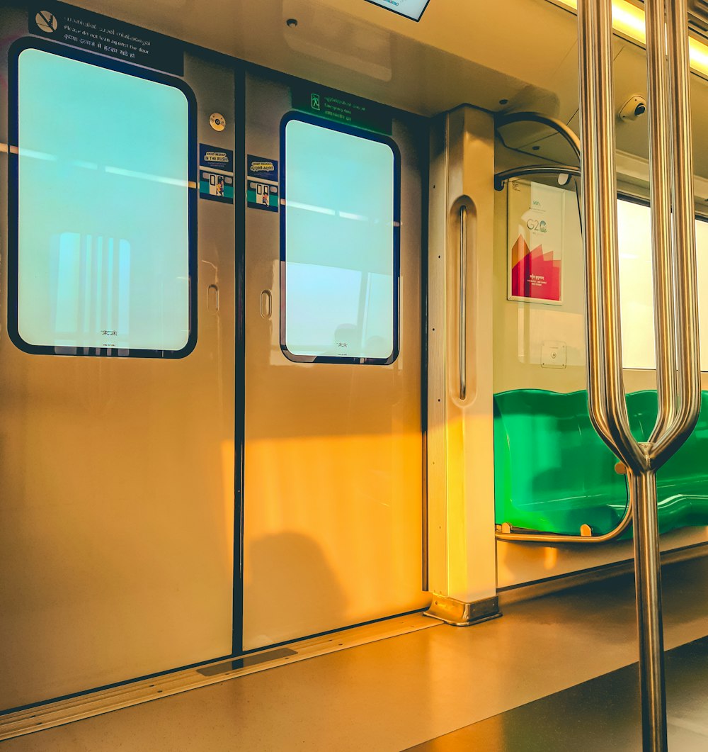 a subway car with green seats and a yellow door