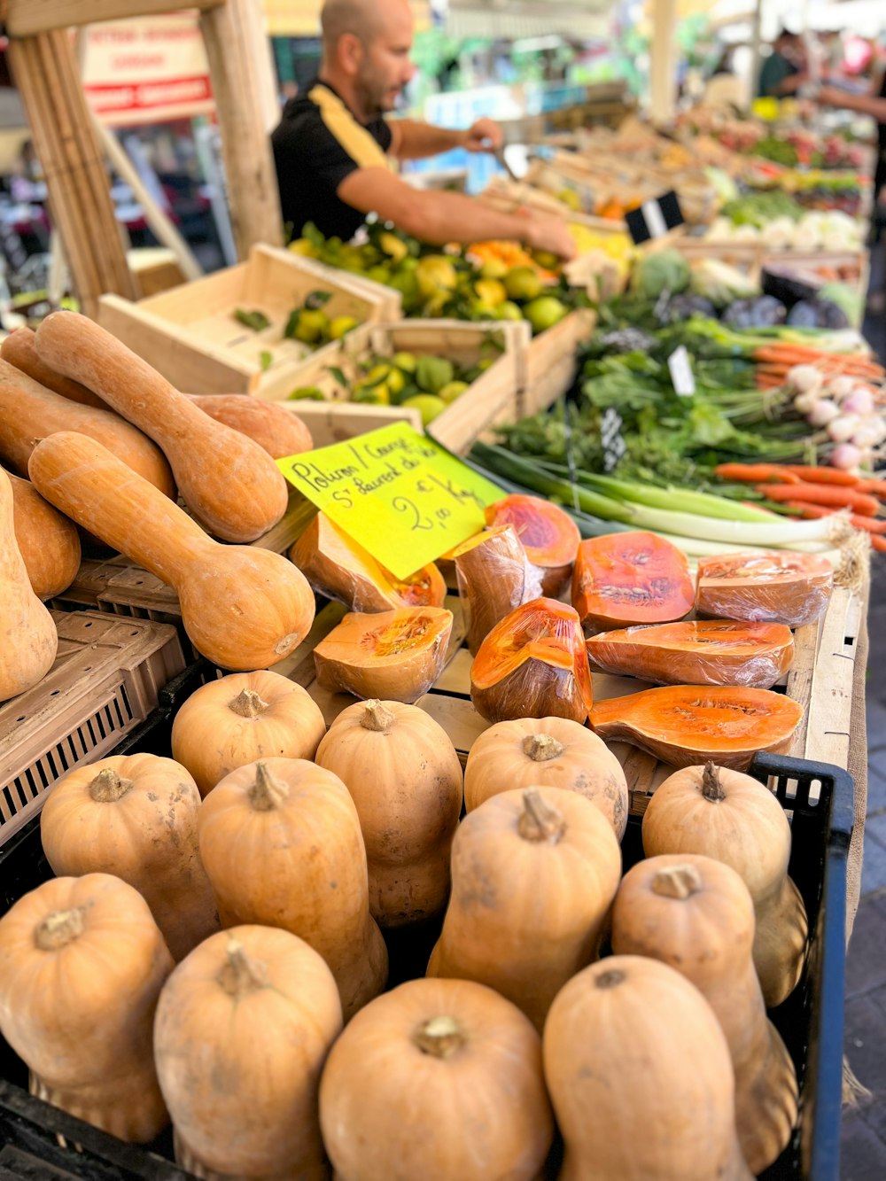 a produce stand with squash and other vegetables