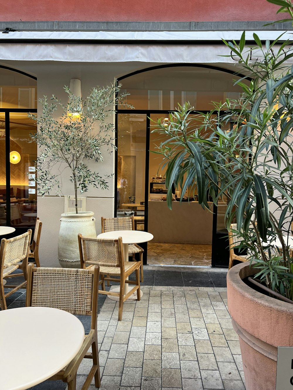 a patio with tables and chairs and a potted plant