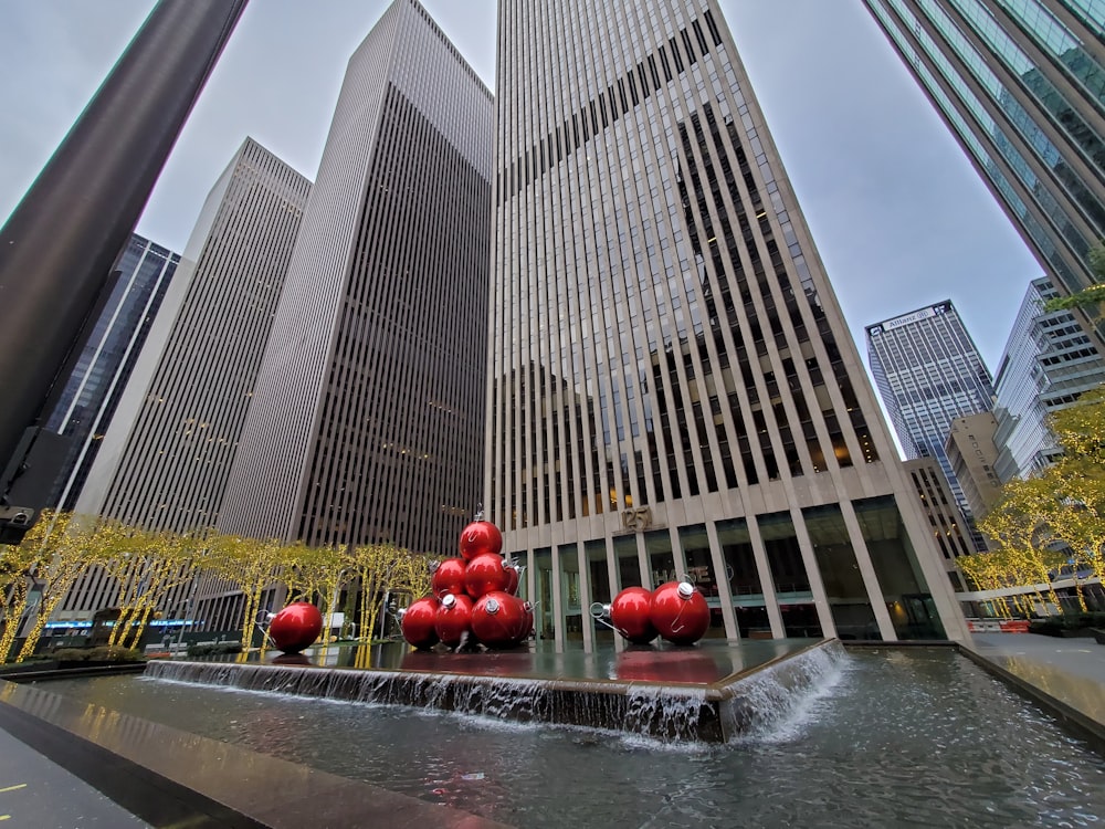 a group of red balls sitting on top of a fountain