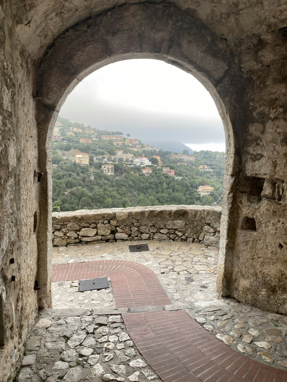 un arco de piedra con una pasarela de ladrillo que conduce a él