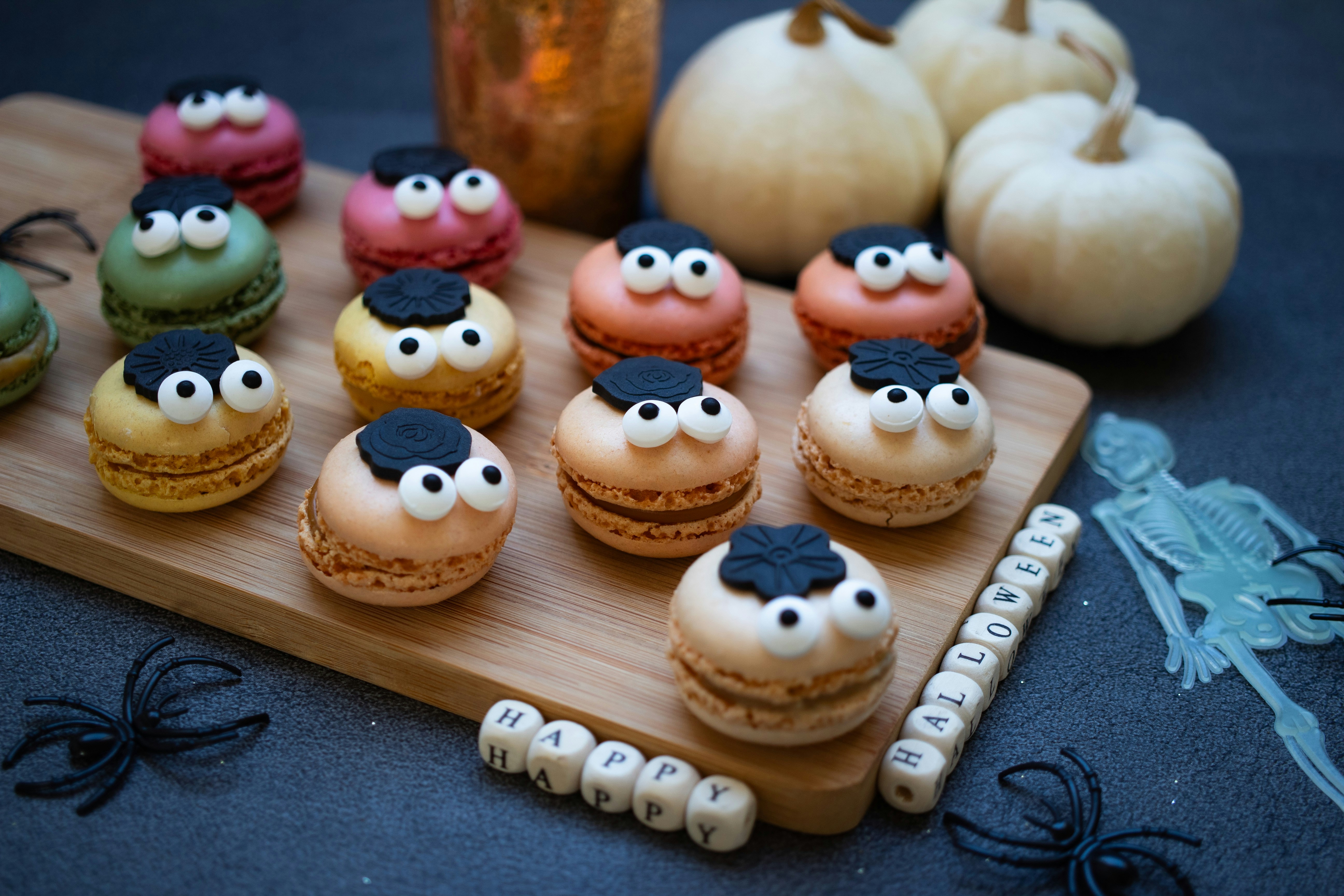 a wooden tray topped with macaroons covered in frosting